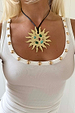 Deloris Sun Necklace featuring a gold sun pendant with semi-precious stones on a black leather cord and white vest top.