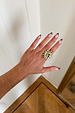 Deloris Sun Ring in brass featuring an iconic sun motif and semi-precious stones, worn on a hand.