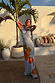 Ice Blue Floral Sophie Dress featuring a draped neckline and orange flower print, styled with a multi-wear scarf on vacation.
