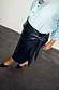 Thumbnail for Iconic Black Vegan Leather Wrap Skirt with a tulip shaped tie, styled with a blue shirt and studded black mules.