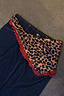 Thumbnail for Multi-wear Cherry Leopard Bandana with a red ruffle border and cherry print, styled as a belt on dark denim.