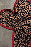Cherry Leopard Bandana featuring leopard print with red cherries and a deep red ruffled border on a textured surface.