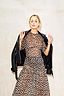 Thumbnail for Leopard Lucia Sheer Dress in iconic leopard print, styled with a black leather jacket draped over the shoulders.