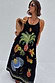 Thumbnail for Black Rio Maxi Dress with hand-painted tropical fruit motifs, styled with a woven bag and sunglasses.