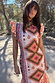 Thumbnail for Bridget Print Frida Dress featuring a multicoloured geometric pattern and feminine frilled sleeves in an outdoor setting.