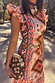 Bridget Print Frida Dress with a multicoloured geometric print and ruffled sleeves, styled with a coin belt.