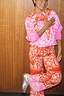 Thumbnail for Red Bandana Wide Leg Trousers Petite in a soft knit with contrast pink hems, styled with a matching co-ord jumper.