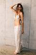 Silver Sequin Bra with adjustable straps, styled with matching trousers against a concrete wall.