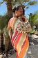 Sunset Stripe Mesh Midi Dress in multicoloured mesh, styled with a beaded bag and sun earrings.