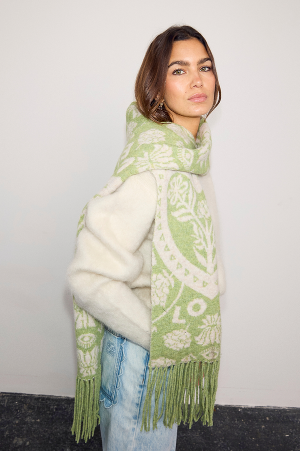 Olive Amara Knit Scarf in green and cream with Mediterranean floral motifs and a long tasseled hem.