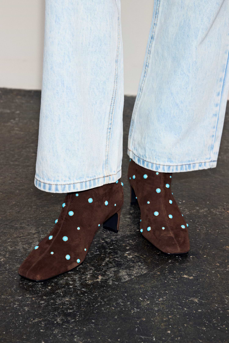 Chocolate Studded Suede Boots in brown suede with turquoise studs, a square toe and block heel, worn with light jeans.