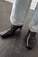 Black leather boots with gold metal studs and a square toe, a wardrobe staple paired with denim.