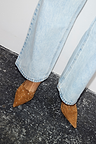 Tan Suede Scallop City Mules with gold studs and scallop edge, paired with light blue wide-leg jeans.