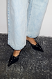 Black Suede Mules featuring scallop edging and silver studs, paired with light-wash blue jeans.