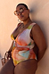 Abstract Plunge Swimsuit in sunset tones with a painterly print and ruched waist on a curve model.