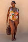 Abstract Plunge Swimsuit in sunset tones with a painterly print, plunging neckline and ruched waist on a curve model.