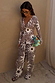 Chocolate Soleil Ellie Trousers in a brown sun motif print, styled as a matching co-ord set with a long-sleeve top.