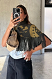 Olive Amara Knit Cape with a turtle neck, tassel fringe and hand-painted motifs, shown on a model.