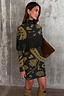 Olive Amara Knit Cape with black tassel fringe and turtle neck in a green floral print on a model.