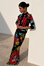 Thumbnail for Black Amara Hollie Cardigan with heart and eye motifs, paired with a matching printed skirt against a wall.