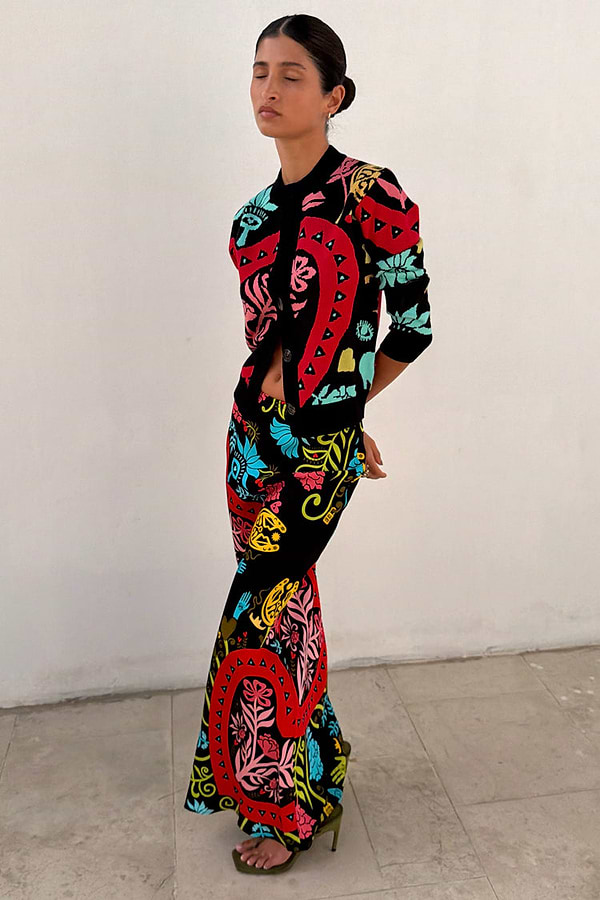 Black Amara Dorris Skirt with vibrant hand-painted heart and eye motifs, styled with a matching cardigan.