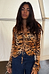 Animal Cali Top in a sheer tiger print with multi-wear tie front detail, paired with high-waisted blue jeans.