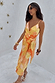 Apricot Strappy Vienna Dress featuring soft orange tones and golden accents in a multi-wear wrap style for vacation.
