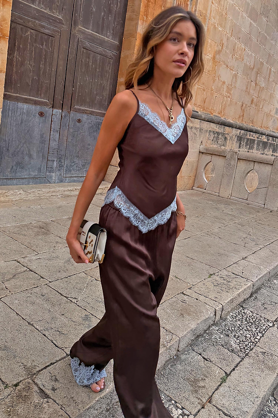 Chocolate Aurelia satin-esque top with blue lace trim, styled with matching trousers on a model walking outdoors.