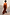 Thumbnail for Chocolate Balloon Jumpsuit with a deep V back and draped silhouette, shown on a model walking outdoors.