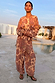 Peach Paisley Balloon Trousers and matching top on a model in a poolside vacation setting.