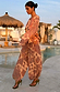 Model wearing Peach Paisley Balloon Trousers as a co-ord in a poolside vacation setting.