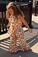 NFD Kids cream cotton banana print co-ord with a peplum top and flared frill trousers on a sunny deck.
