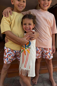 Girl's cream banana print jersey cotton dress with a fringe hem and stripe trim, styled with matching banana shorts.