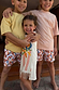 Girl's cream banana print jersey cotton dress with a fringe hem and stripe trim, styled with matching banana shorts.