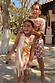Cream Banana Jersey Cotton Dress with orange stripes and fringe hem, worn by a young girl on vacation.