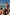 Thumbnail for Cream Boy's Banana Print Swim Shorts with a multi-coloured pattern, worn by children on a sunny beach vacation.