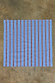 Blue Cotton Stripe Bandana with red and white vertical stripes, laid flat on a textured stone surface.