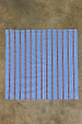 Blue Cotton Stripe Bandana with red and white vertical stripes, laid flat on a textured stone surface.