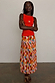 Cirque Beatrice Skirt in a colourful harlequin geometric print with a pleated A-line midi silhouette on a model.