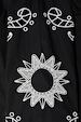Black Enchanted Lillie Top detail featuring white sun and paisley embroidery with intricate cut-out motifs.