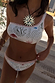 Cream Palma one-shoulder bikini top with hand-painted sun motifs and orange crochet trim.