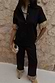 Black Raffia Marra Trousers with fringe hems, styled as a co-ord with a matching shirt and raffia clutch.