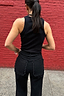 Thumbnail for Black Scallop Detail Jeans featuring a wide leg and scalloped pockets, styled with a black tank top against a red wall.
