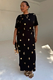 Black Shell Midi Leia Dress featuring a gold shell print and wrap tie waist on a model.