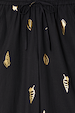 Black Shell Elissa Trousers detail showing the elasticated drawstring waist and metallic gold shell print.