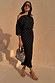 Black Tilly Dress with gold foil flecks and an off-shoulder neckline in plisse, styled on a model outdoors.