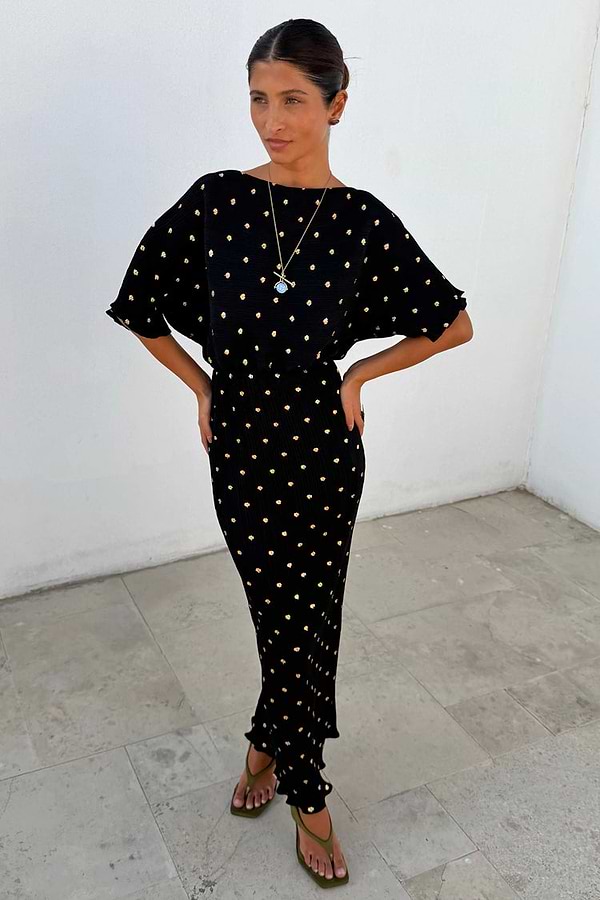 Black Tilly Dress in shimmering gold foil plisse featuring an off-shoulder neckline and delicate lettuce hem.