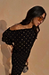 Black Tilly Dress with gold foil flecks and an off-the-shoulder neckline in a textured plisse fabric.