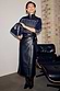 Black Vegan Leather Jaspre Wrap Skirt with a tulip-shaped tie, styled for a London look with a navy jacket.