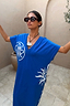 Blue Dolce Vita cotton T-shirt dress featuring white sun motifs and Greek graphics, styled with sunglasses.